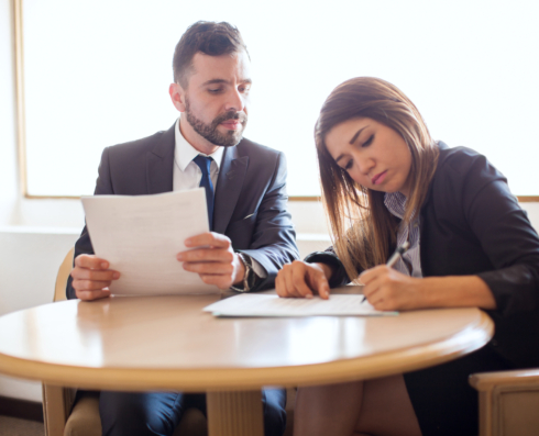 Photo of two colleagues writing on a paper