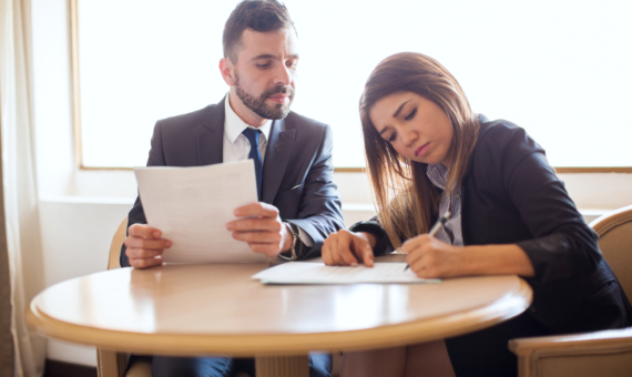Photo of two colleagues writing on a paper